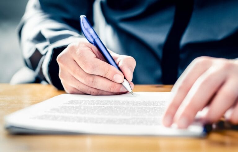 Persona firmando un documento de carta poder
