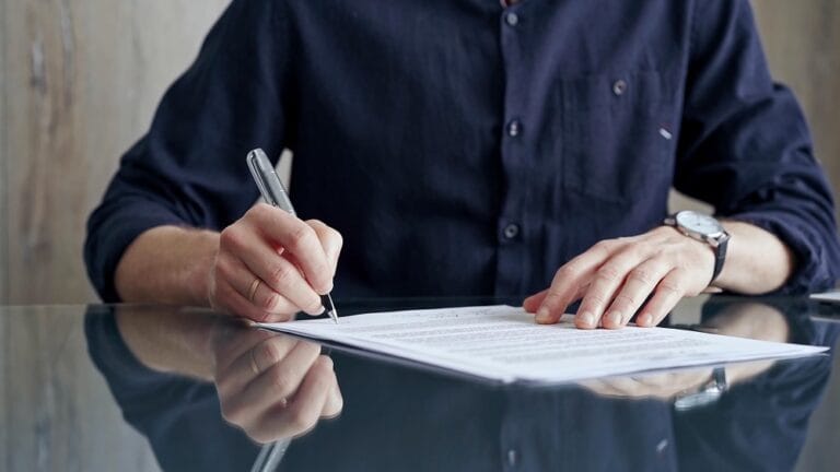 Persona firmando un documento notarial de sucesión intestada en Perú