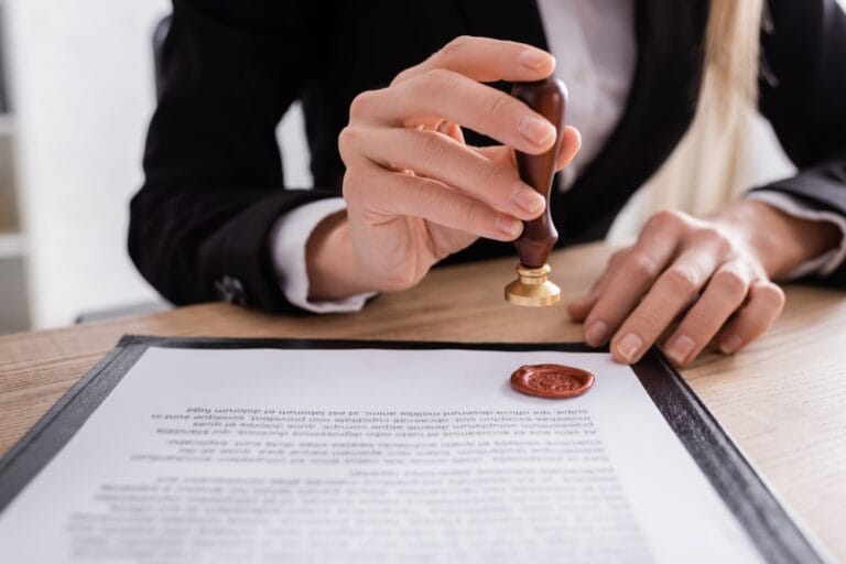 Notario colocando sello de lacre sobre documento certificado